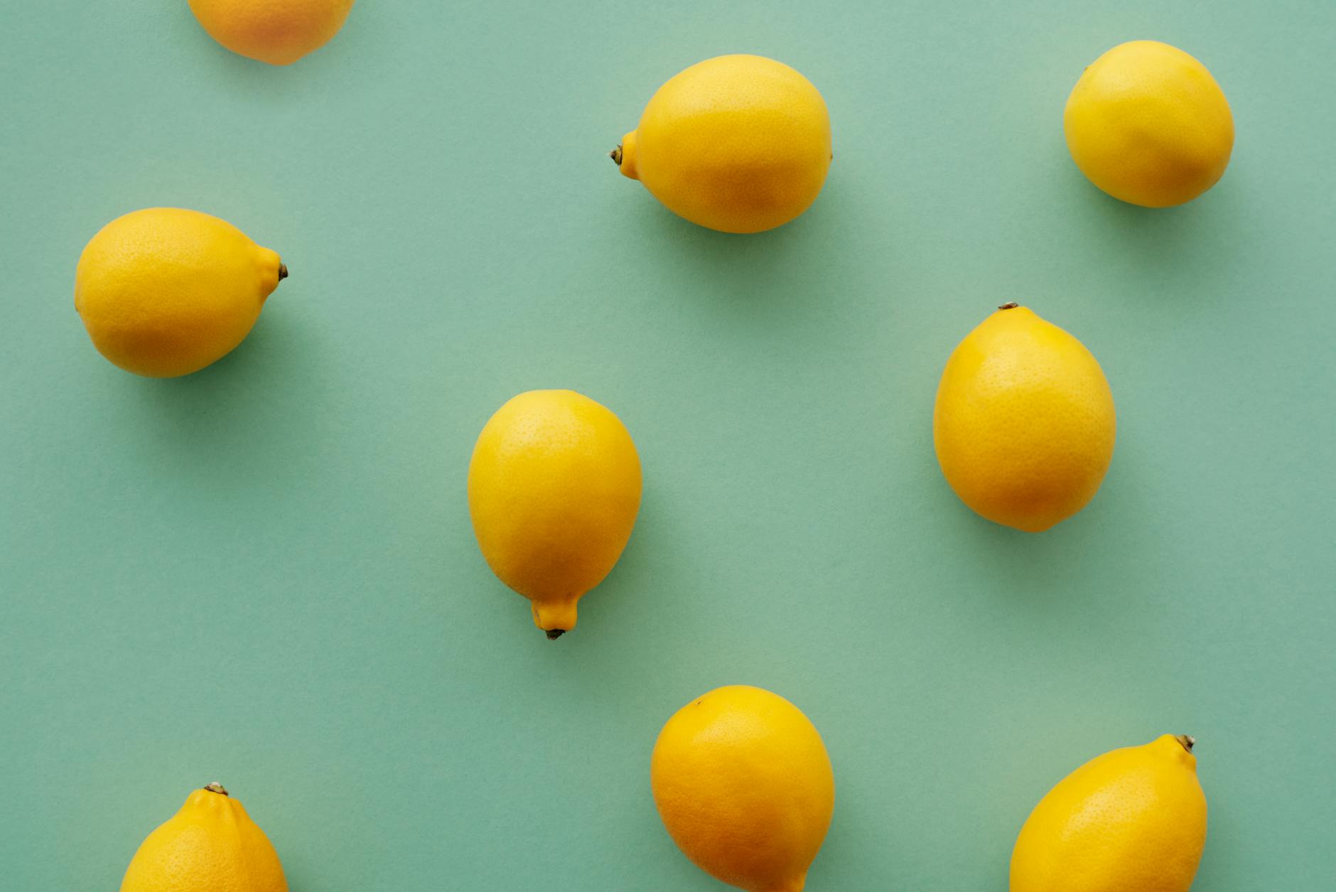 Woman holding fresh lemon at dining table, symbolizing renewal and fresh starts