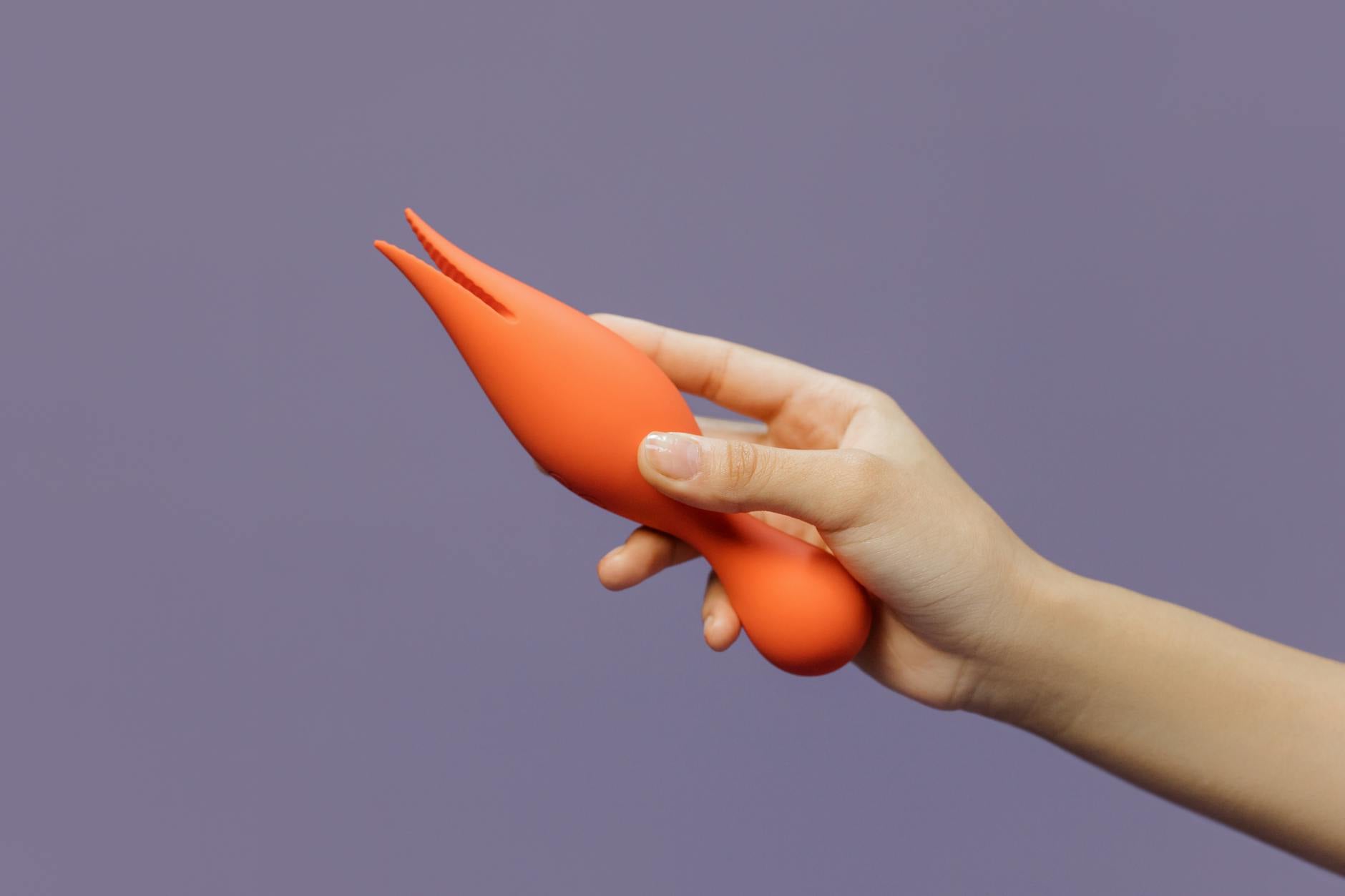 Hand holding a lemon on a soft pink background